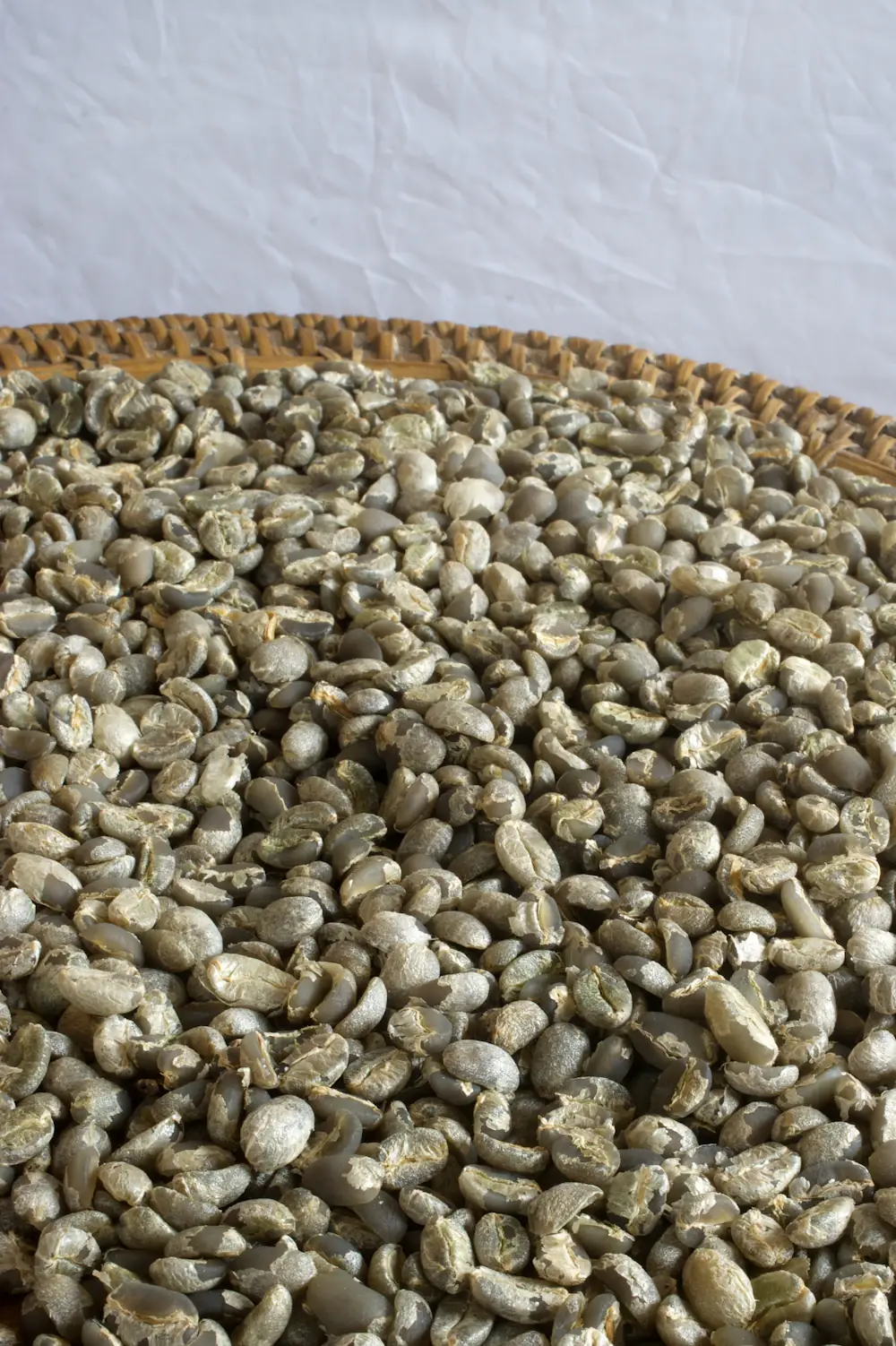Raw green coffee beans in a wicker basket